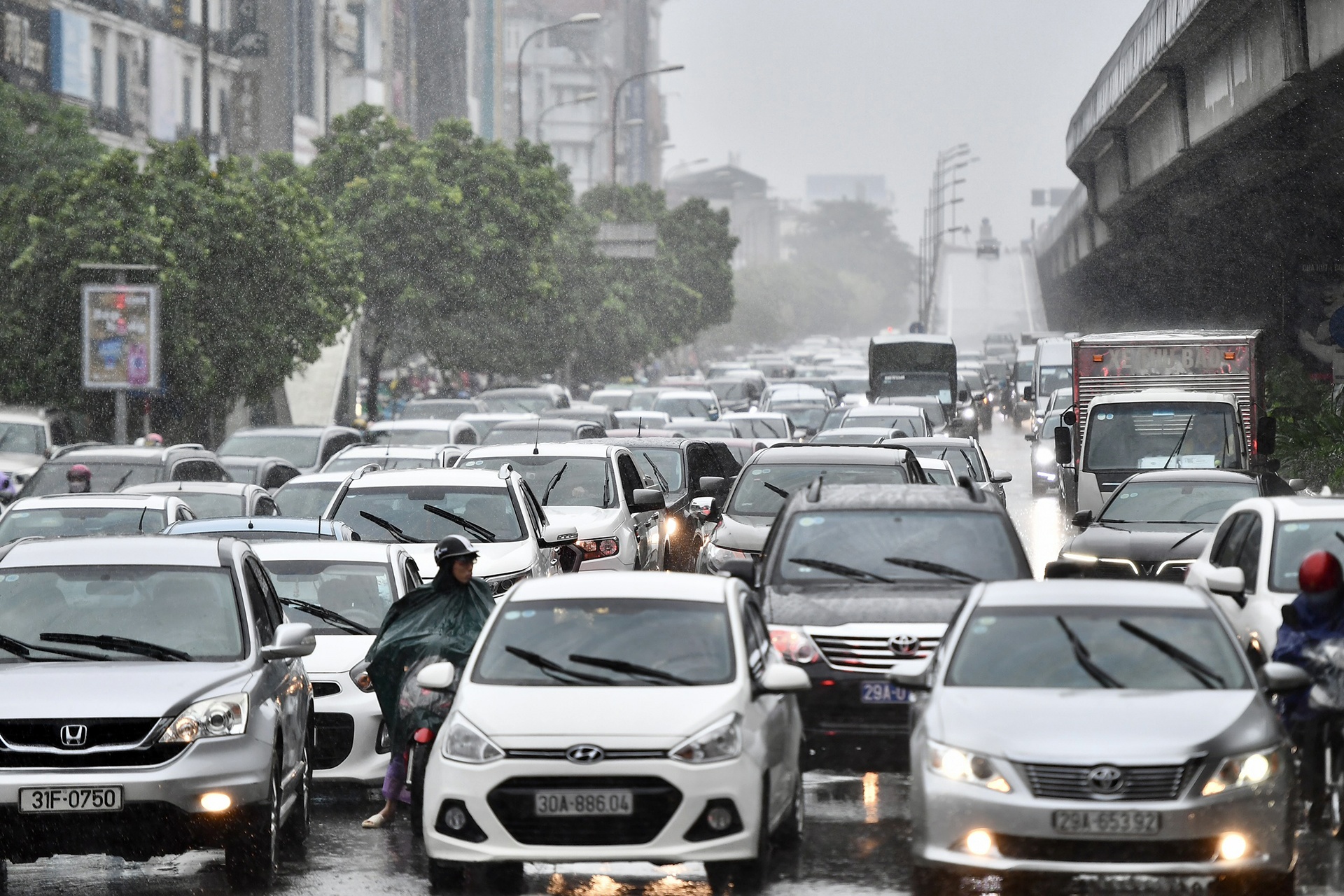 Nguoi di duong chat vat trong tran mua sang dau tuan hinh anh