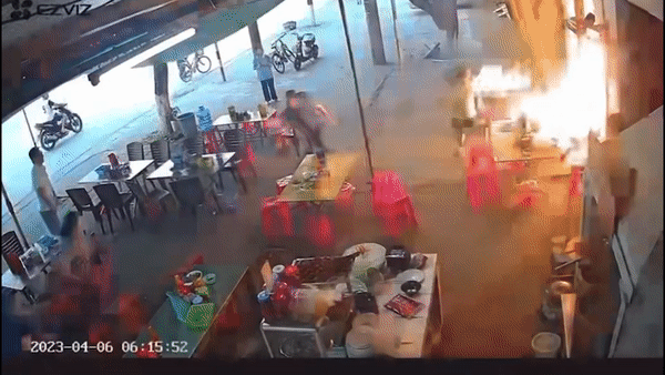 Nguoi dan ong dung tay keo binh ga dang chay ra khoi nha hinh anh