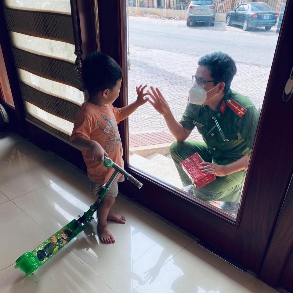 Chiến sĩ công an chia tay con qua cửa kính để đi chống dịch ảnh 1 Chien si cong an chia tay con qua cua kinh de di chong dich anh 1