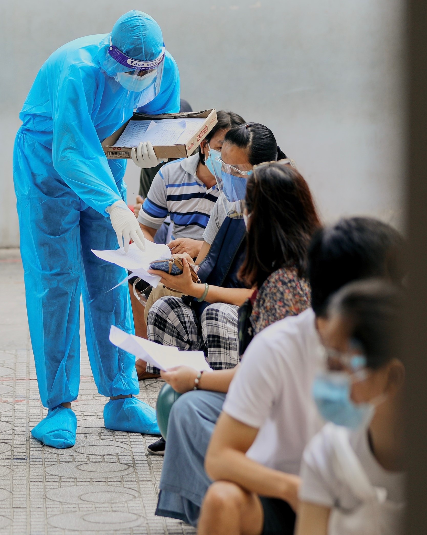 Tinh nguyen vien o TP.HCM cho cu ba om de do so khi tiem vaccine anh 3