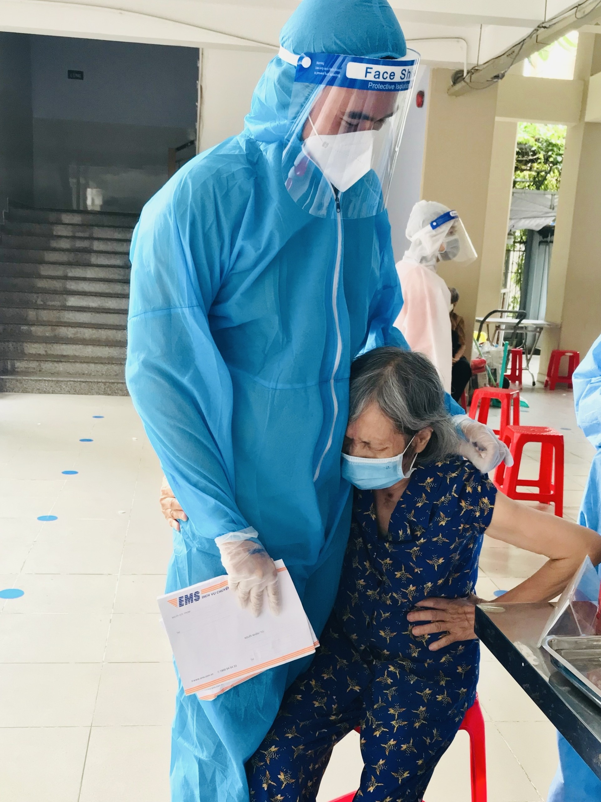 Tinh nguyen vien o TP.HCM cho cu ba om de do so khi tiem vaccine anh 2