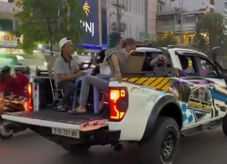 Nhom nguoi ngang nhien an uong tren thung xe ban tai giua duong TP.HCM hinh anh