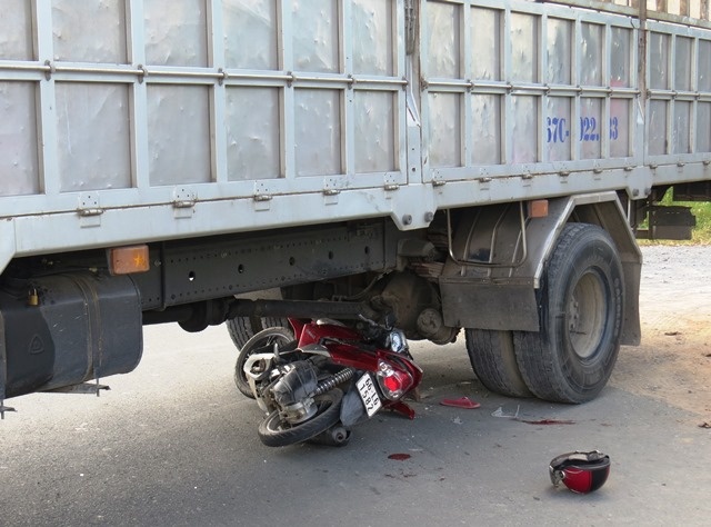 Moto chui vao gam xe tai, 2 nguoi chan thuong nang hinh anh