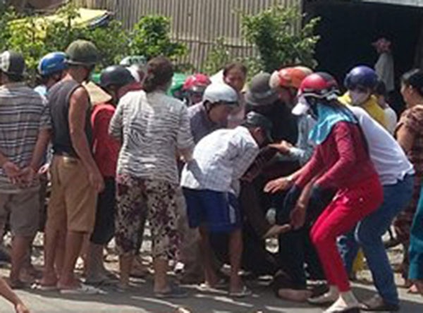 Mẹ cô gái trong vòng tay chăm sóc của người dân khi ngất xỉu tại hiện trường. Ảnh Minh Anh