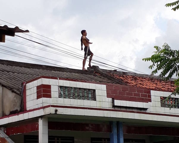 Thanh nien nghi ngao da ‘co thu’ tren noc nha, nem ngoi vao canh sat hinh anh