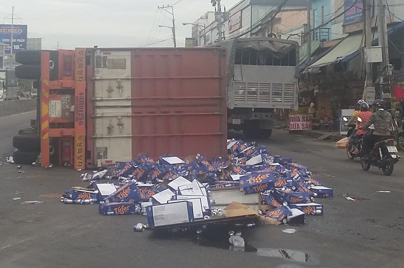 Xe container lat tren quoc lo 1, hang tram thung bia do ra duong hinh anh