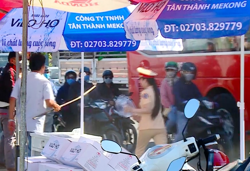 Nguoi dan ong cam gay xua duoi nu CSGT phat nuoc mien phi cho dan hinh anh