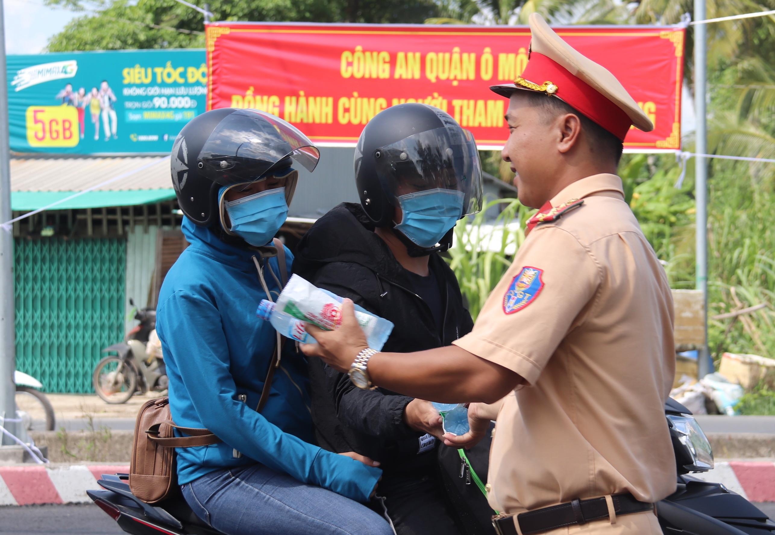 Canh sat phat nuoc suoi mien phi cho nguoi dan ve mien Tay nghi le hinh anh