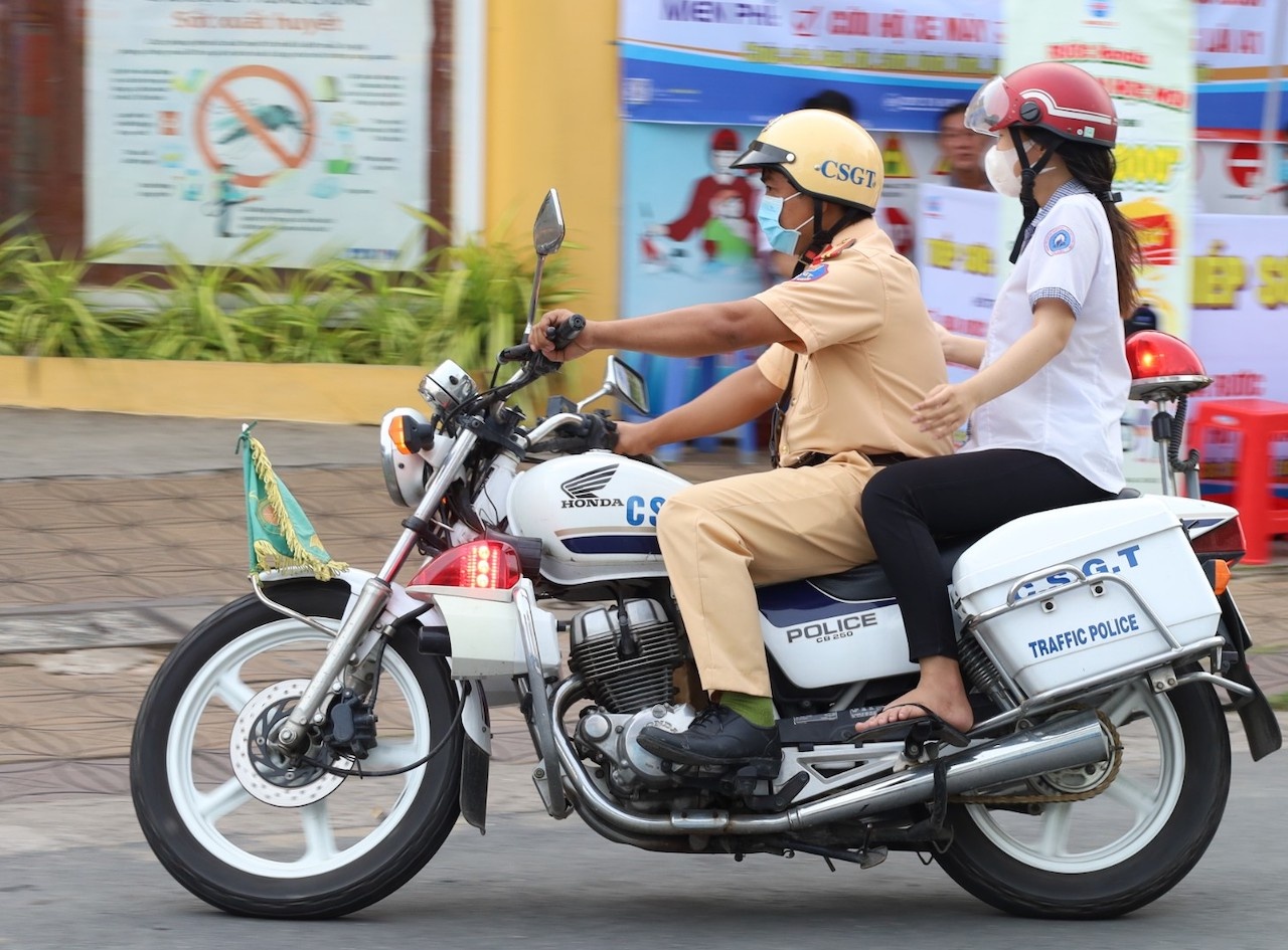 Thieu ta CSGT dung xe dac chung cho nu sinh ve nha lay giay bao du thi hinh anh