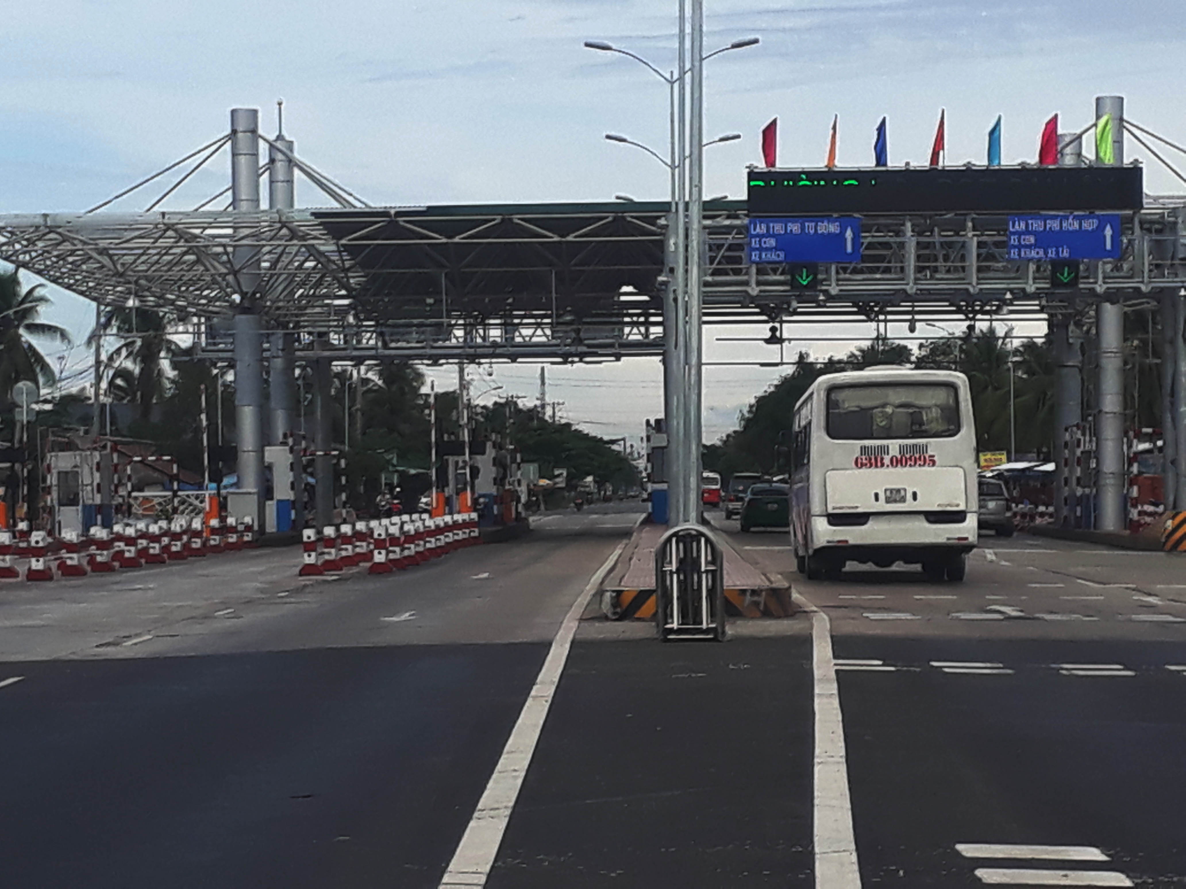 Tai xe dung tien le nhet chai nhua qua tram thu phi hinh anh