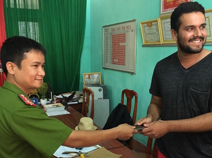 Anh Yver Feraaz vui vẻ nhận lại điện thoại iPhone 5s do công an huyện Bố Trạch trao trả. Ảnh: Công an cung cấp.