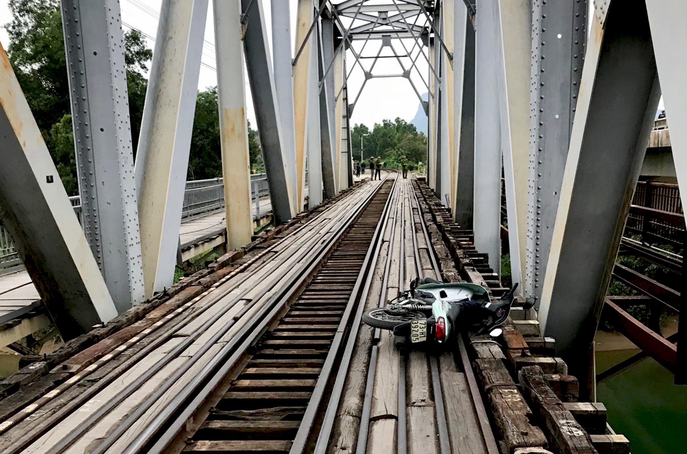 Nguoi dan ong tu nan khi di xe may qua cau duong sat hinh anh