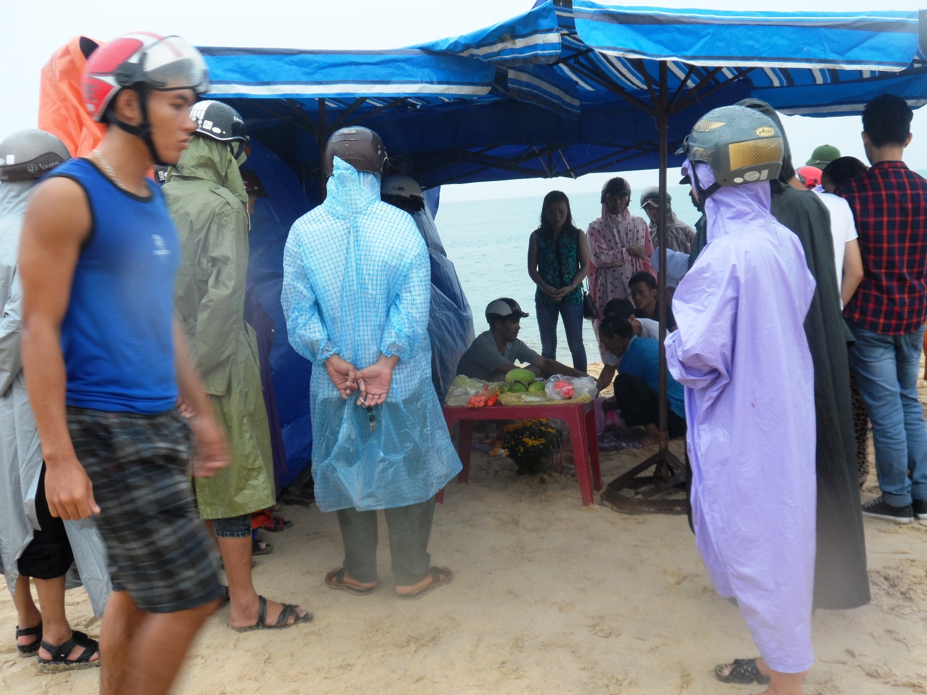 Người dân địa phương cùng với người thân đang tiến hành thủ tục khâm liệm cho nạn nhân