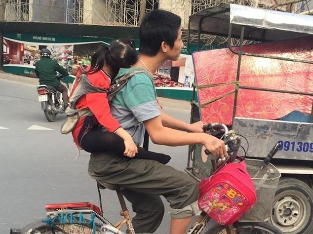 Nguoi cha diu con dap xe di nhat rac gay xuc dong hinh anh