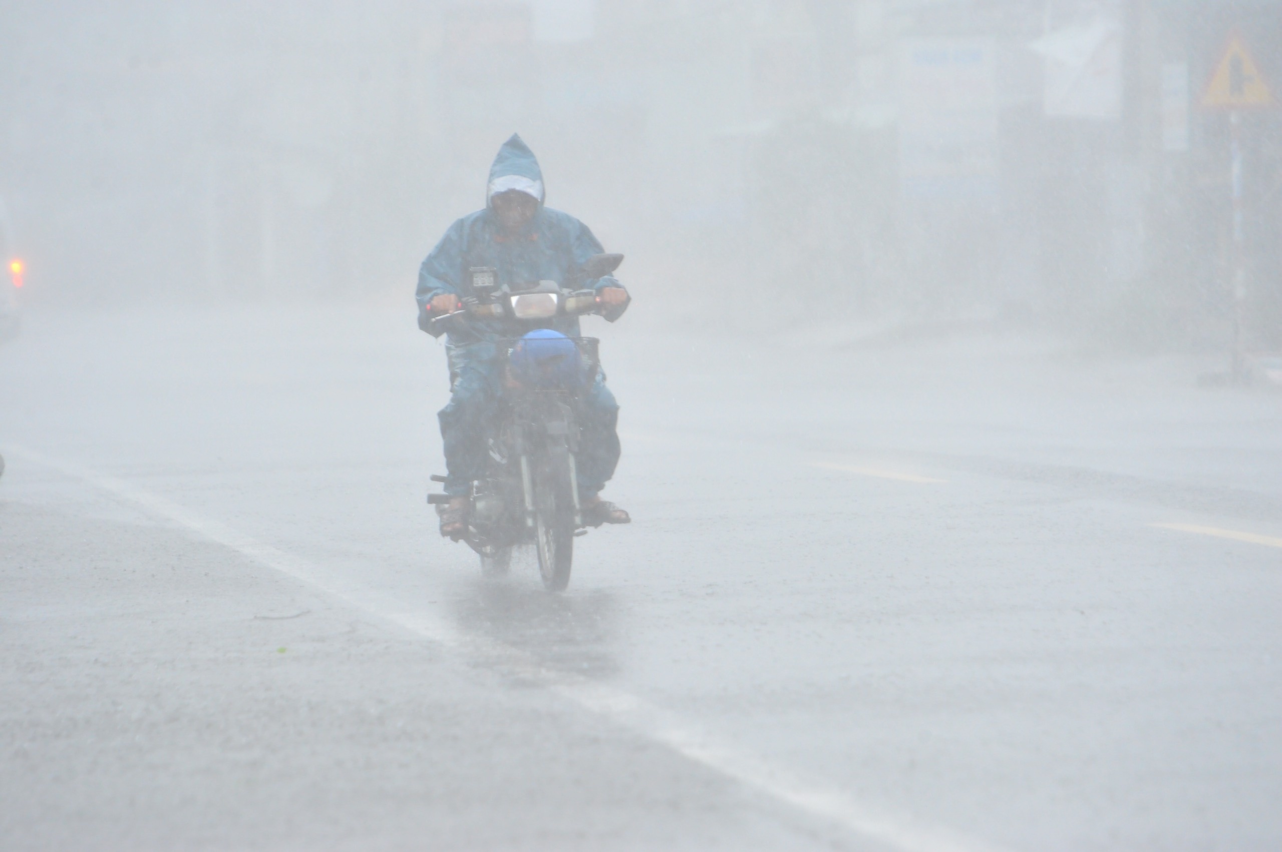 Cong an cuu nguoi dan ong dap xe qua cau song Han trong mua bao hinh anh