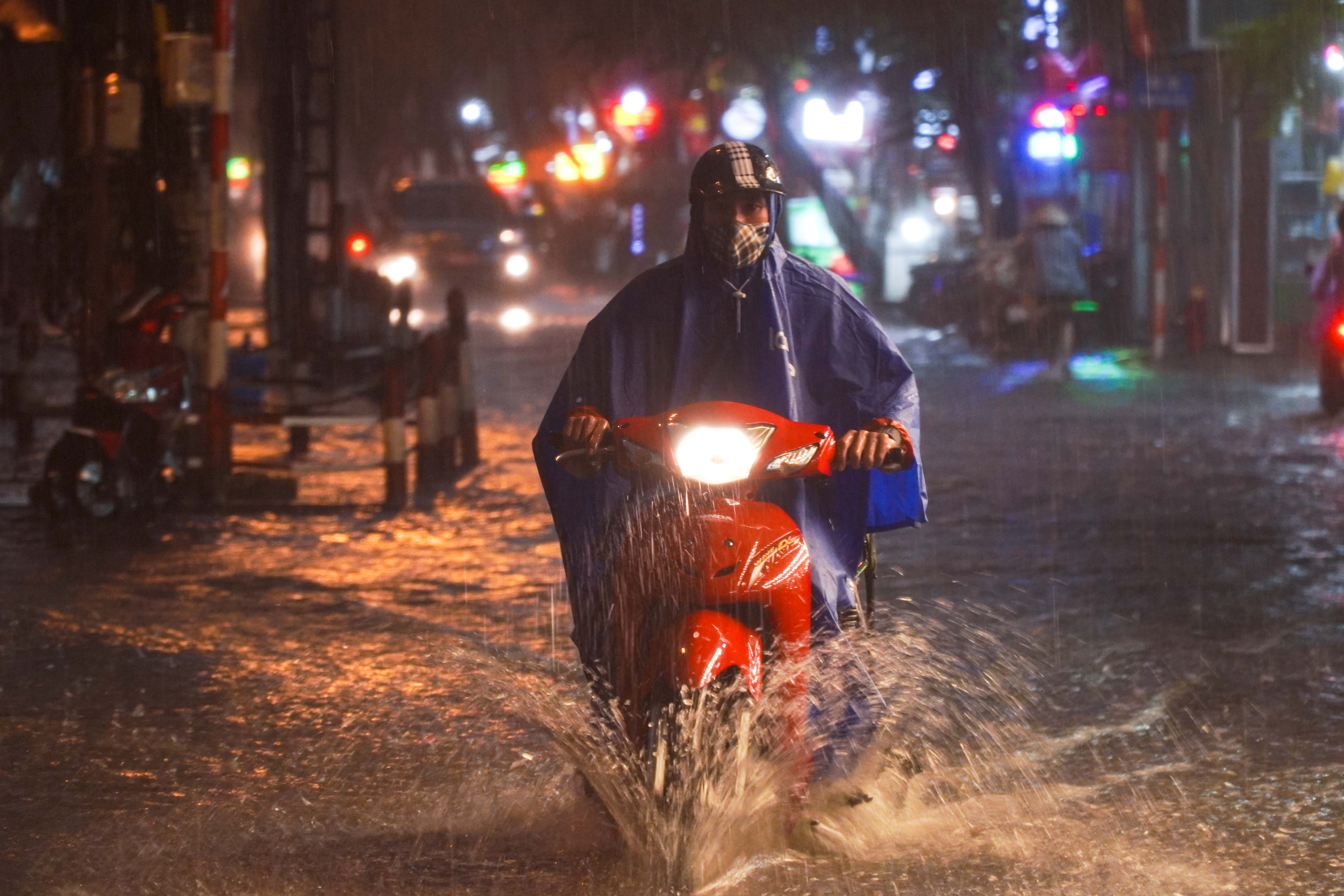 Nguoi Ha Noi day xe may trong con mua lon hinh anh