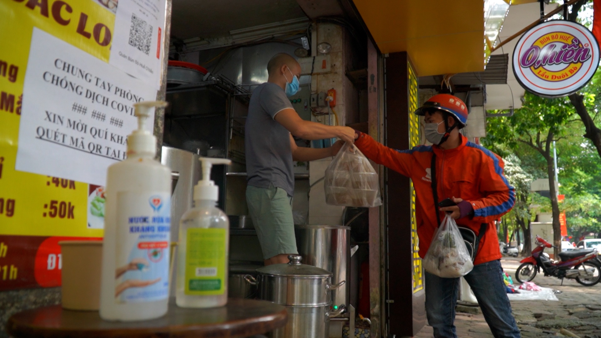 Shipper giao do an tat bat trong ngay dau Ha Noi moi long gian cach hinh anh