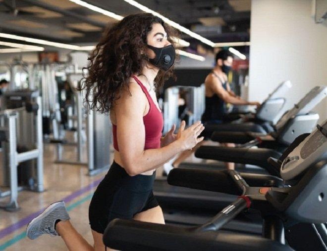 Deo khau trang chay bo trong ngay phong gym mo cua hinh anh