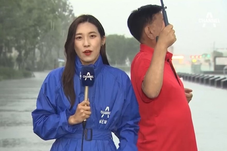 Nguoi qua duong che mua cho MC thoi tiet hinh anh