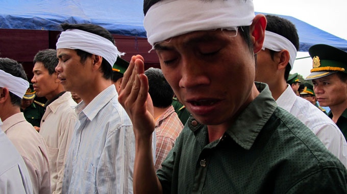 Em trai út của trung tá Nguyễn Văn Đãi khóc nức nở bên linh cữu anh trai. Ảnh Tuổi trẻ