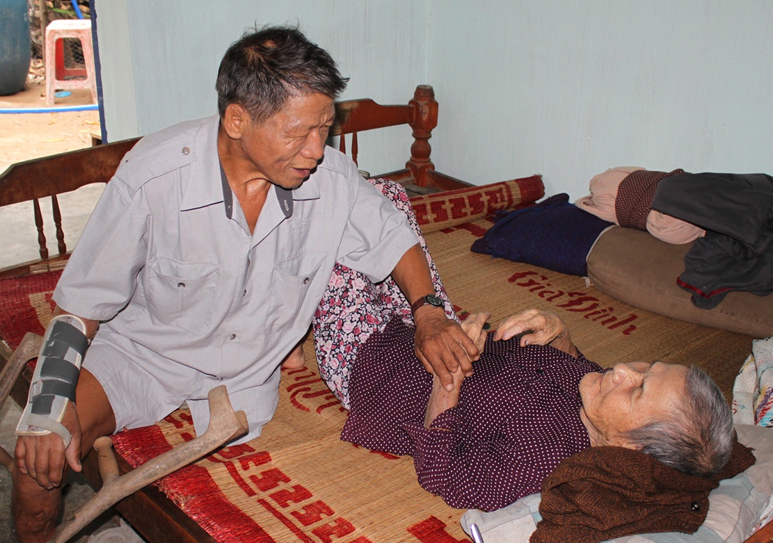 Thương binh Nông Minh Đức chăm sóc cho cụ Lê Thị La. Ảnh: Ngọc An