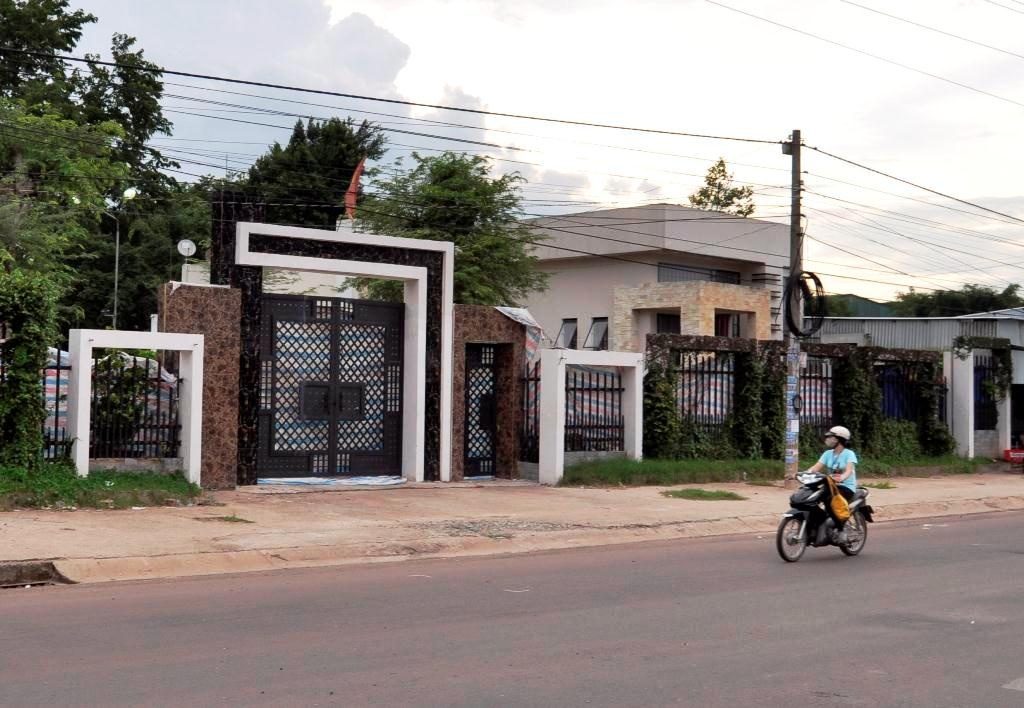 Lực lượng chức năng dùng bạt nhựa che chắn khu vực trong cổng chính và tường rào ngôi nhà xảy ra thảm sát. Ảnh: Ngọc An