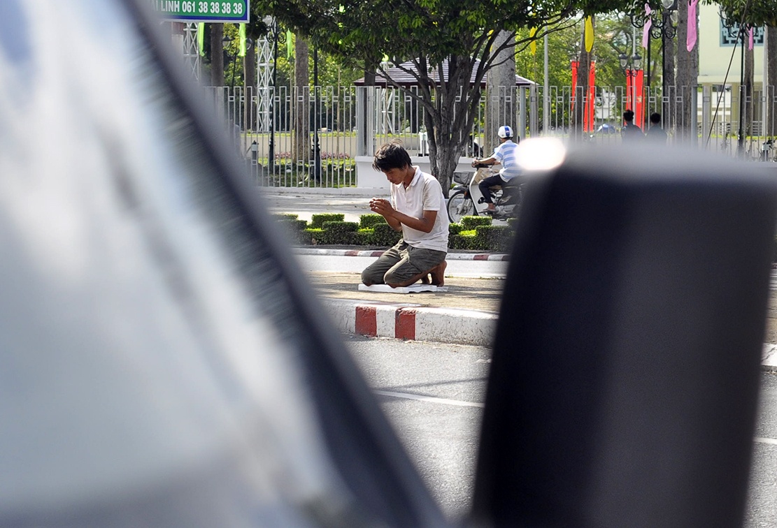 Thanh nien quy lay lien tuc duoi troi nang xin tien hinh anh