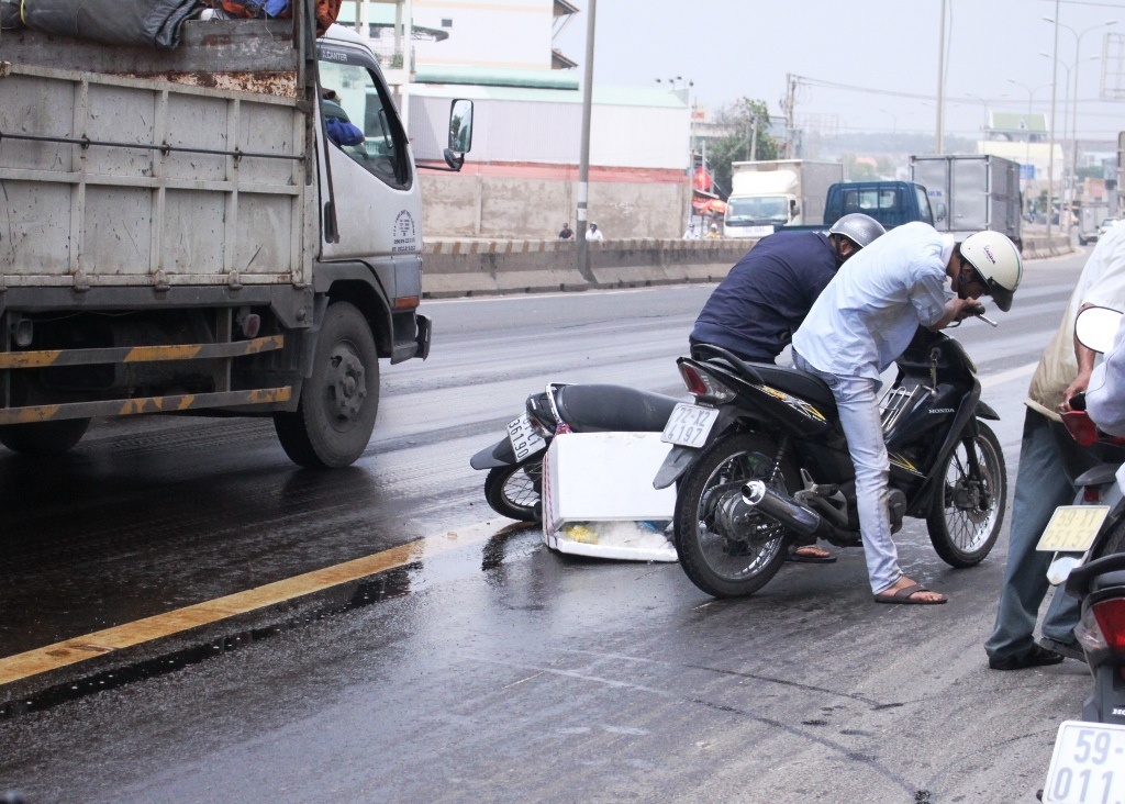 Dau tran tren quoc lo, nguoi di xe may truot nga hinh anh