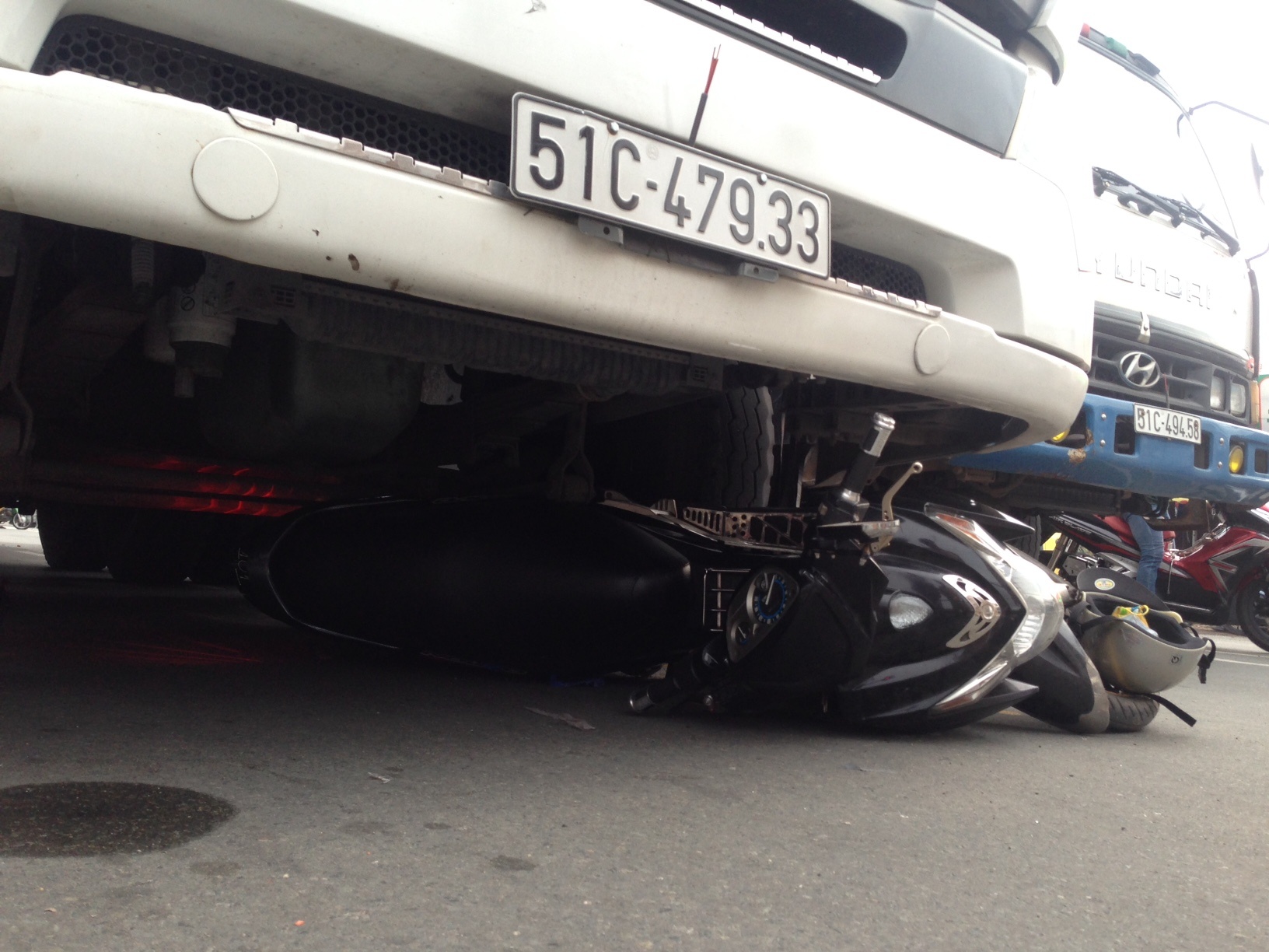 Nguoi phu nu bi xe container cuon vao gam hinh anh