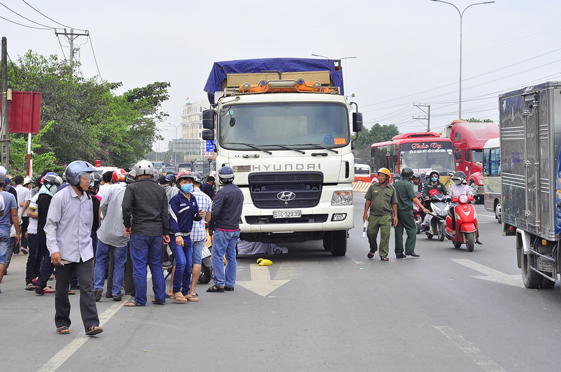 Hai chi em ruot tu vong duoi banh xe tai hinh anh