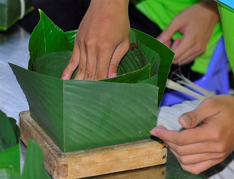 Cap tap lam banh chung phuc vu Tet hinh anh