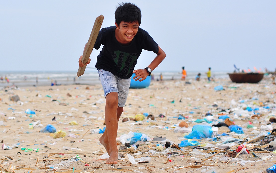 Tre em choi dua tren bai bien ngap rac hinh anh