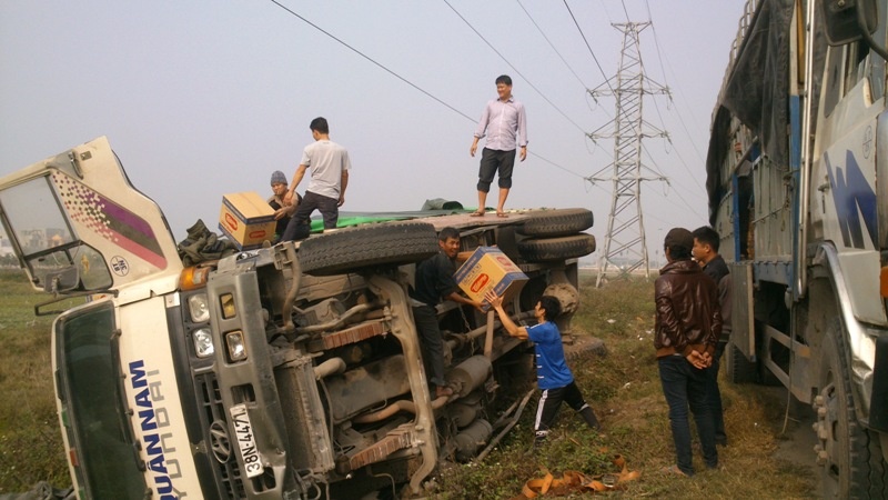 Xe cho hang Tet bi lat, dan giup tai xe thu gom hang hinh anh
