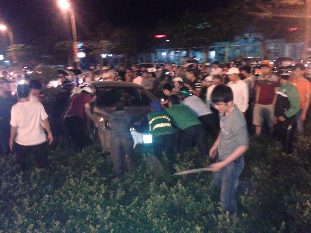 Hàng chục người dân hợp sức đẩy chiếc xe xuống đường.