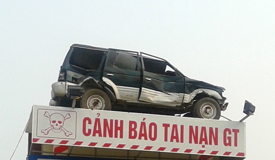 Trên cùng là chiếc xe bị tai nạn nát bét và dòng chữ xung quanh: