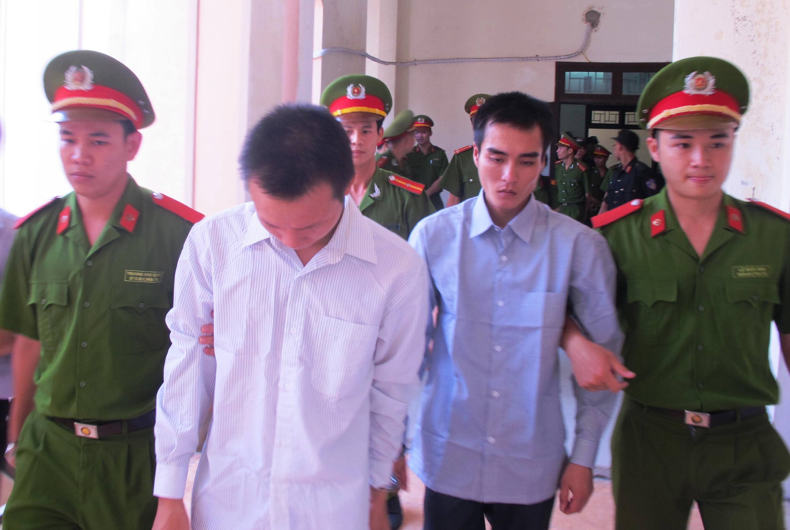 Hai bị cáo Tú và Trọng được công an dẫn giải ra xe sau khi kết thúc phiên tòa.