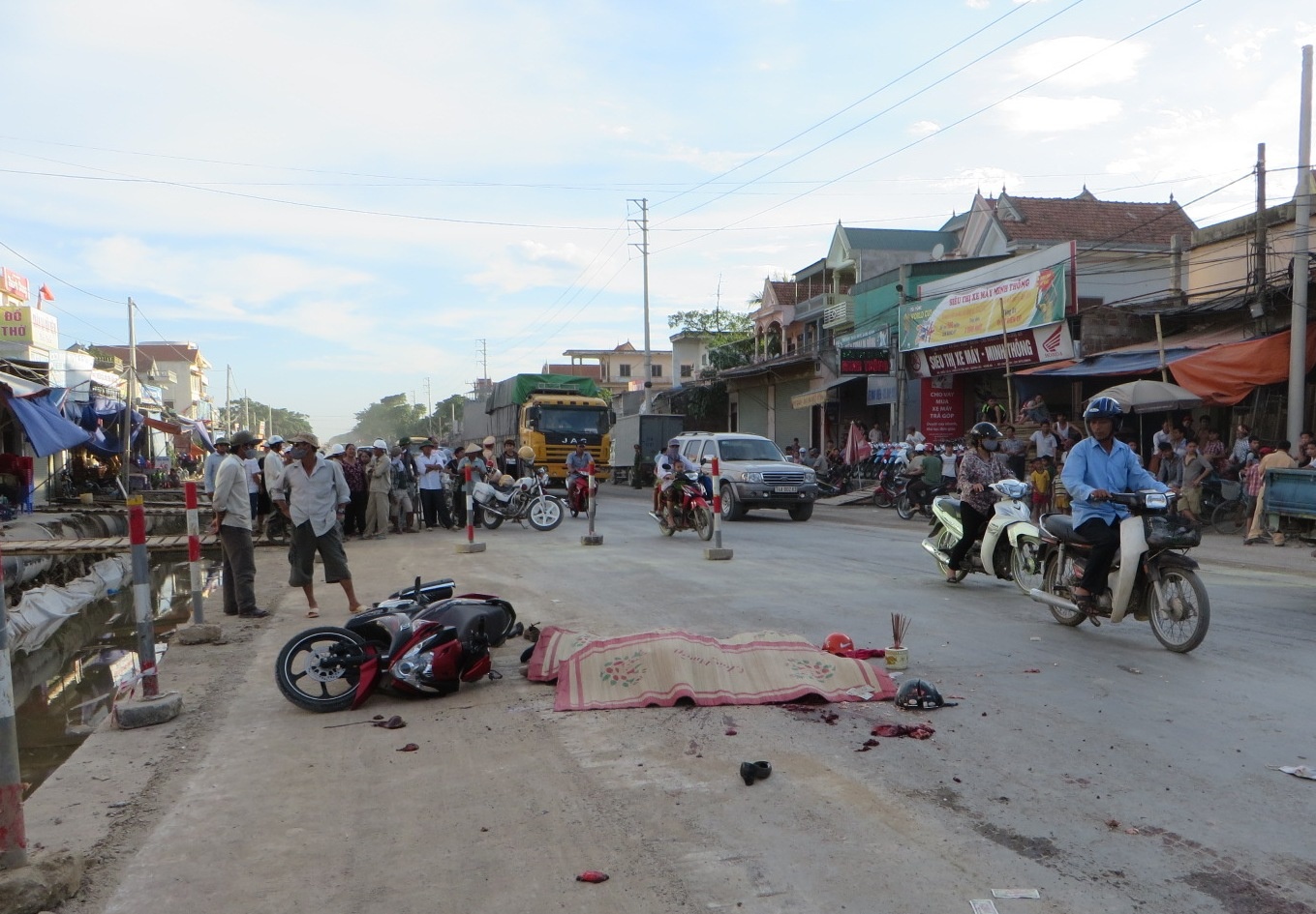 Doi nam nu chet tham sau khi bi xe container can ngang nguoi hinh anh