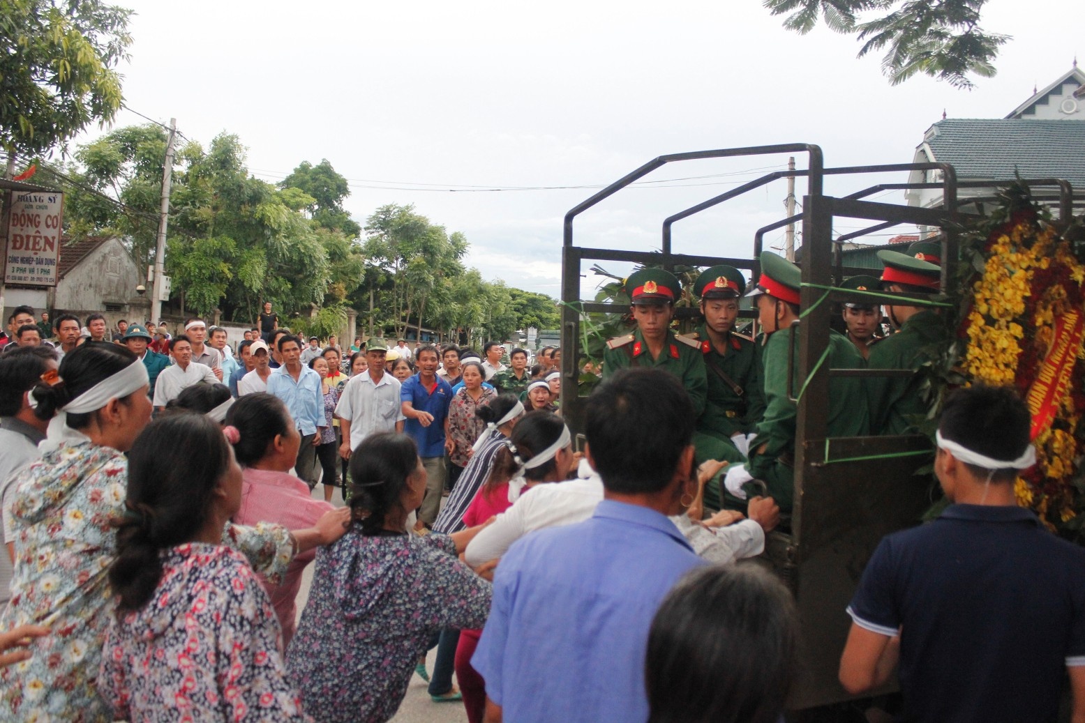 Khi chiếc xe vừa cua vào ngõ vào nhà ông Nguyễn Sỹ Hiền (63 tuổi) và bà Đinh Thị Hoa (61 tuổi), là bố mẹ chiến sĩ Hợi thì người thân và bà con ùa theo.