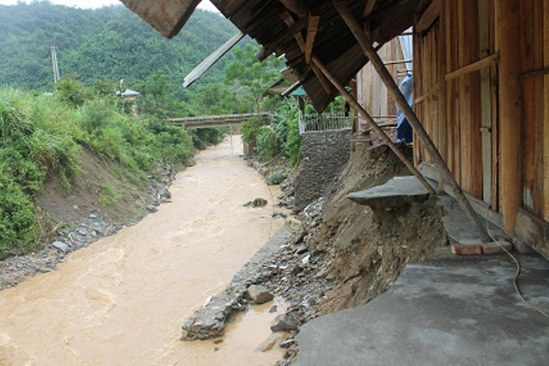 Nhà của một hộ dân bị sạt lở nghiêm trọng, nằm chênh vênh bên vực sâu, cạnh con suối.