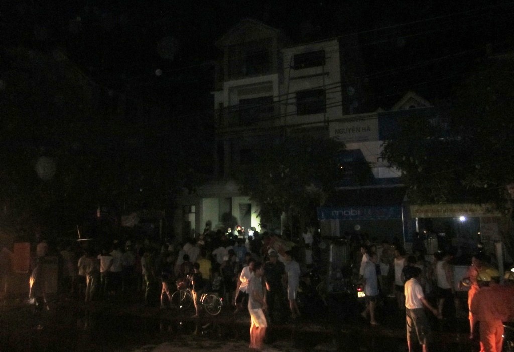 Ngôi nhà nơi xảy ra đám cháy. Hàng trăm người dân tập trung xem cứu hỏa dập lửa.