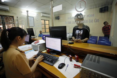 Thực hiện Kế hoạch của Bộ Công an, Cục CSGT đường bộ-đường sắt về đăng ký, quản lý phương tiện, Phòng CSGT Công an Hà Nôj (PC67) đã tổ chức tập huấn cho CBCS CSGT làm công tác đăng ký, quản lý phương tiện tại Công an 30 quận, huyện, thị xã… . Trong ảnh:  Chị Nguyễn Thị Hoàng Trang là người dân đầu tiên đến làm thủ tục đăng ký xe máy bằng hình thức bốc biển (5 số) qua máy vi tính sáng 25/10.