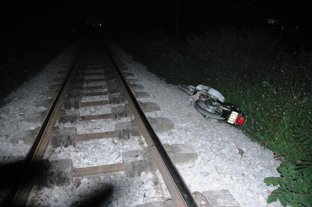 Chiếc xe máy cùng người ngồi trên xe bị tàu kéo đi hàng chục mét.