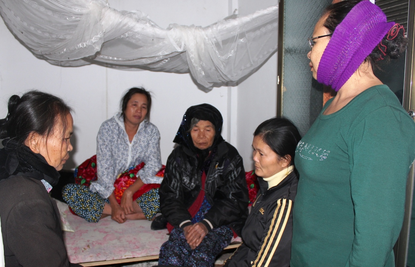 Bà Sơn (áo hoa) từ lúc nghe tin con gặp nạn đến giờ chỉ biết khóc ngất gọi tên con. Bà được những người phụ nữ láng giềng ngồi cạnh chăm sóc.