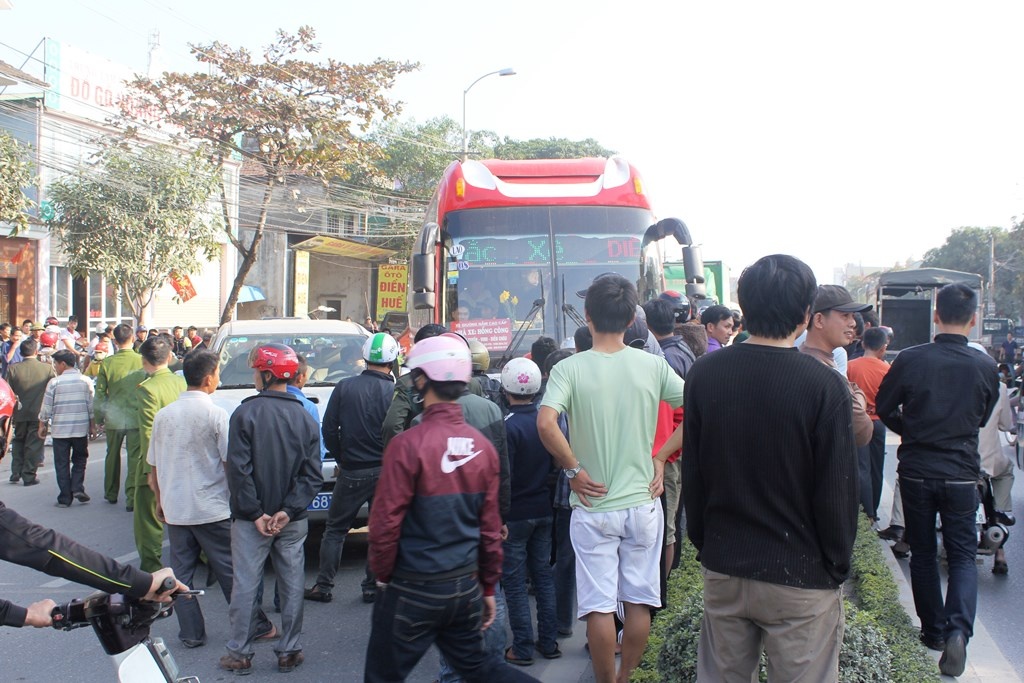 Lực lượng chức năng cùng hàng trăm người dân hiếu kì vây lấy chiếc xe nghi chở gỗ lậu.