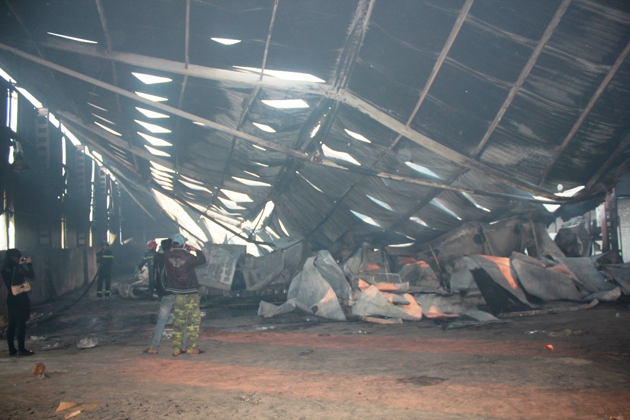 Toàn bộ khung nhà xưởng bị đám cháy thiêu đổ sập xuống nền, bên trong vẫn còn một vài  điểm có khói bốc lên. 