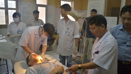 Các bác sĩ Bệnh viện Đa khoa Sơn Tây đang khâu vết thương cho nạn nhân Đỗ Bá Đồng. 