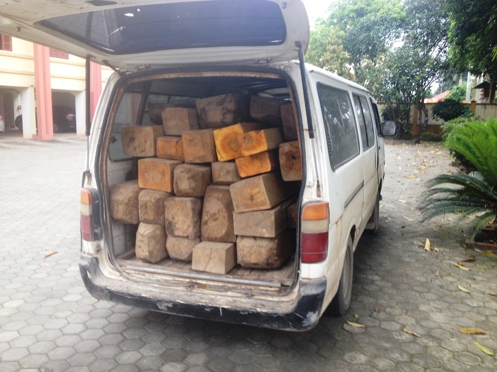 Chiếc xe 12 chỗ chở 28 khúc gỗ không rõ nguồn gốc tại cơ quan công an.