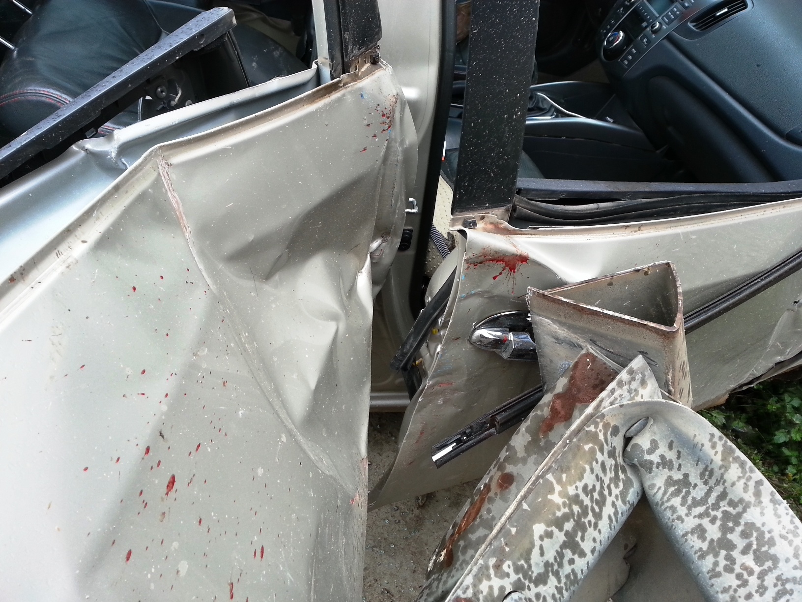 Cửa sau của ôtô cùng bánh sau bị nát hoàn toàn và văng ra xa. Cửa trước bị bung ra ngoài. 