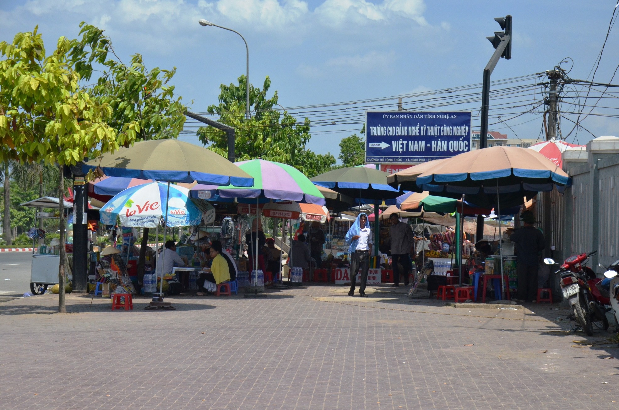 Trước cửa Bệnh viện đa khoa Nghệ An, người dân chen nhau dưới những chiếc ô di động. Trời nắng nóng cũng khiến bệnh nhân tăng cao, đặc biệt là bệnh về đường hô hấp.