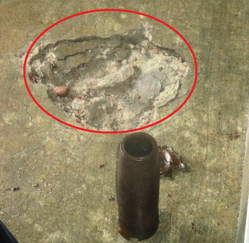 Ống dã thuốc súng và vết thủng trên nền nhà nơi đặt ống sắt (vòng tròn đỏ). Ảnh: H. Phương.